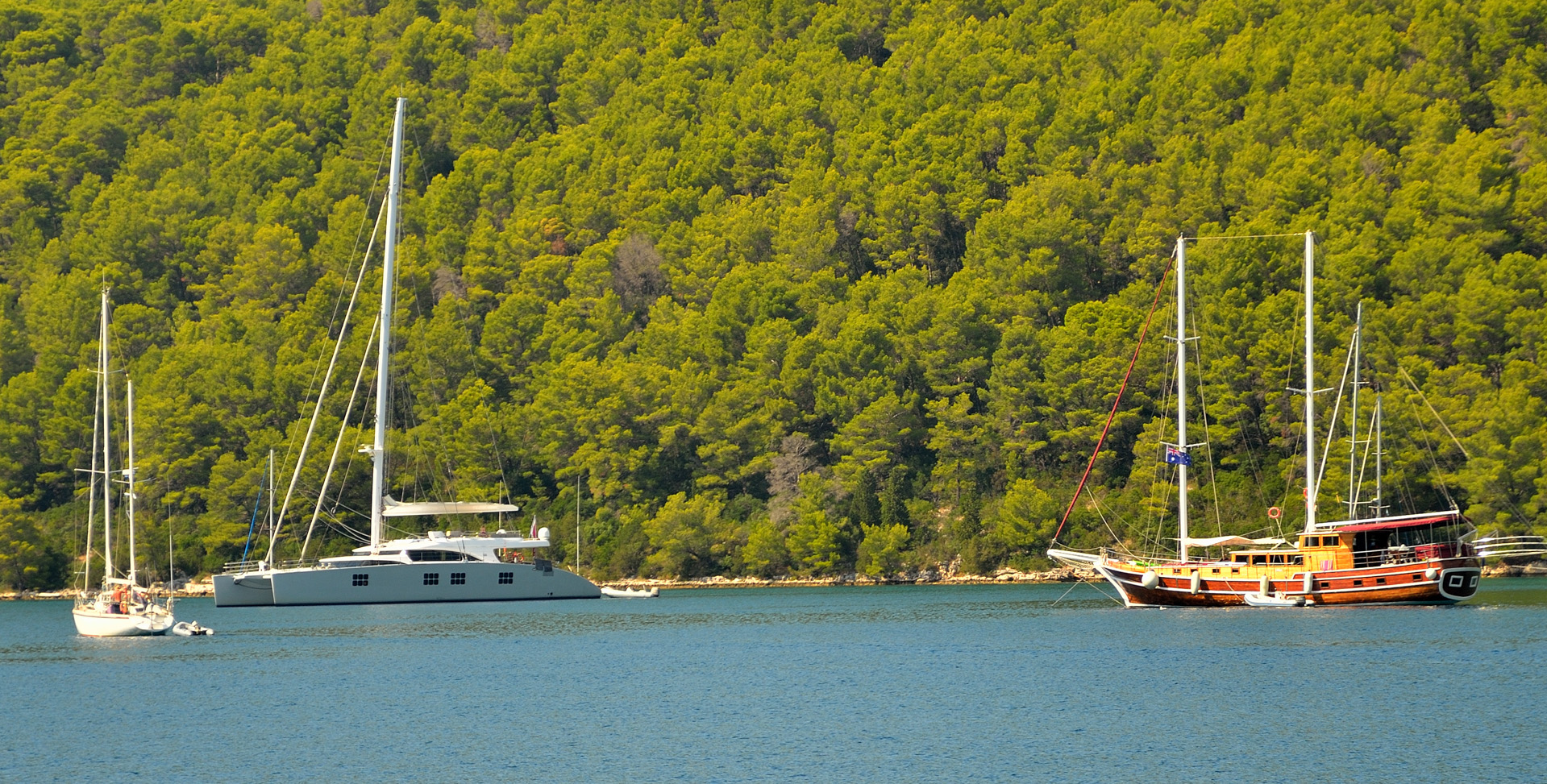 Katamaran und Party-Boot in der Bucht von Polace...