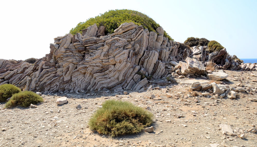 Hier ist deutlich zu sehen, dass die Insel Kreta sich im 4. Jahrhundert n. Chr. im Osten senkte und im Westen hob. Als geologische Besonderheit befindet sich auf dem Rücken des ‚Krokodils‘ die Felsformation einer Gesteinsfaltung. Farblich unterschiedliche Gesteinsschichten bilden ein wellenförmiges Streifenmuster.