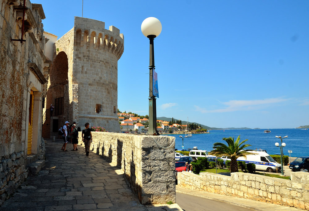 ...Im Mittelalter wurde die Stadt Korčula von einem geschlossenen Befestigungsring mit Stadtmauern, viereckigen und runden Wehrtürmen und zwei Stadttoren umgeben. Auch heute ist die Stadtbefestigung noch gut zu erkennen, folgt die Uferpromenade in weiten Teilen der einstigen Befestigung...