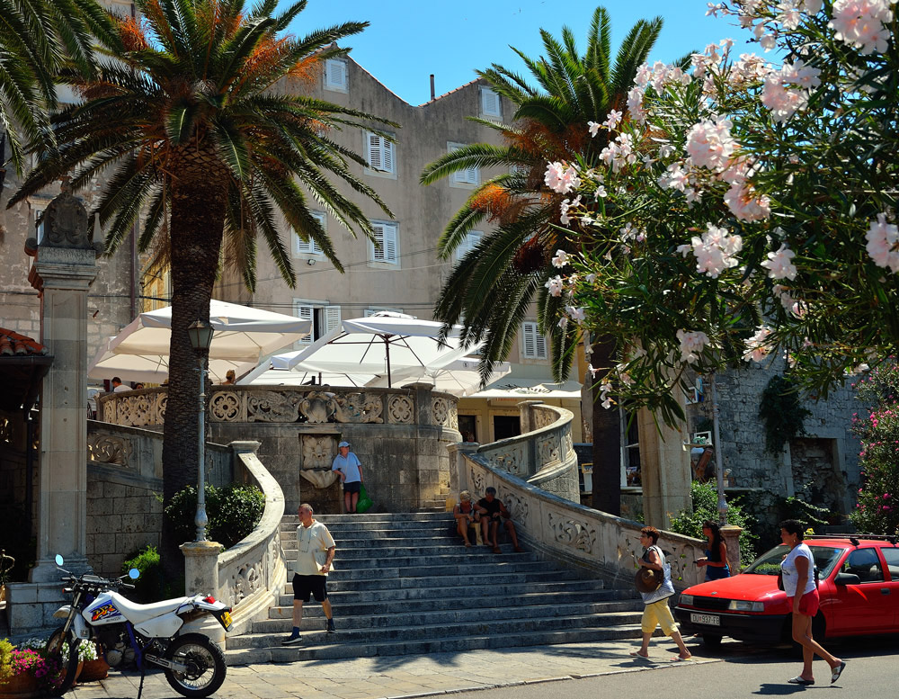...Hinter dem kleinen Hafentorturm (Kula morska vrata) führt eine Treppe in die Stadt hinein. Links neben der Treppe steht die venzianische Loggia, in der heute die Touristeninformation untergebracht ist. Gleich dahinter befindet sich das Hotel Korčula...