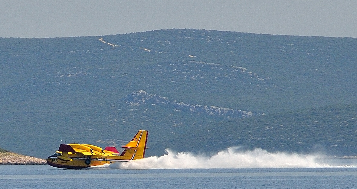 Direkt neben uns füllt die Canadair CL-415 ihre Tanks mit Löschwasser...