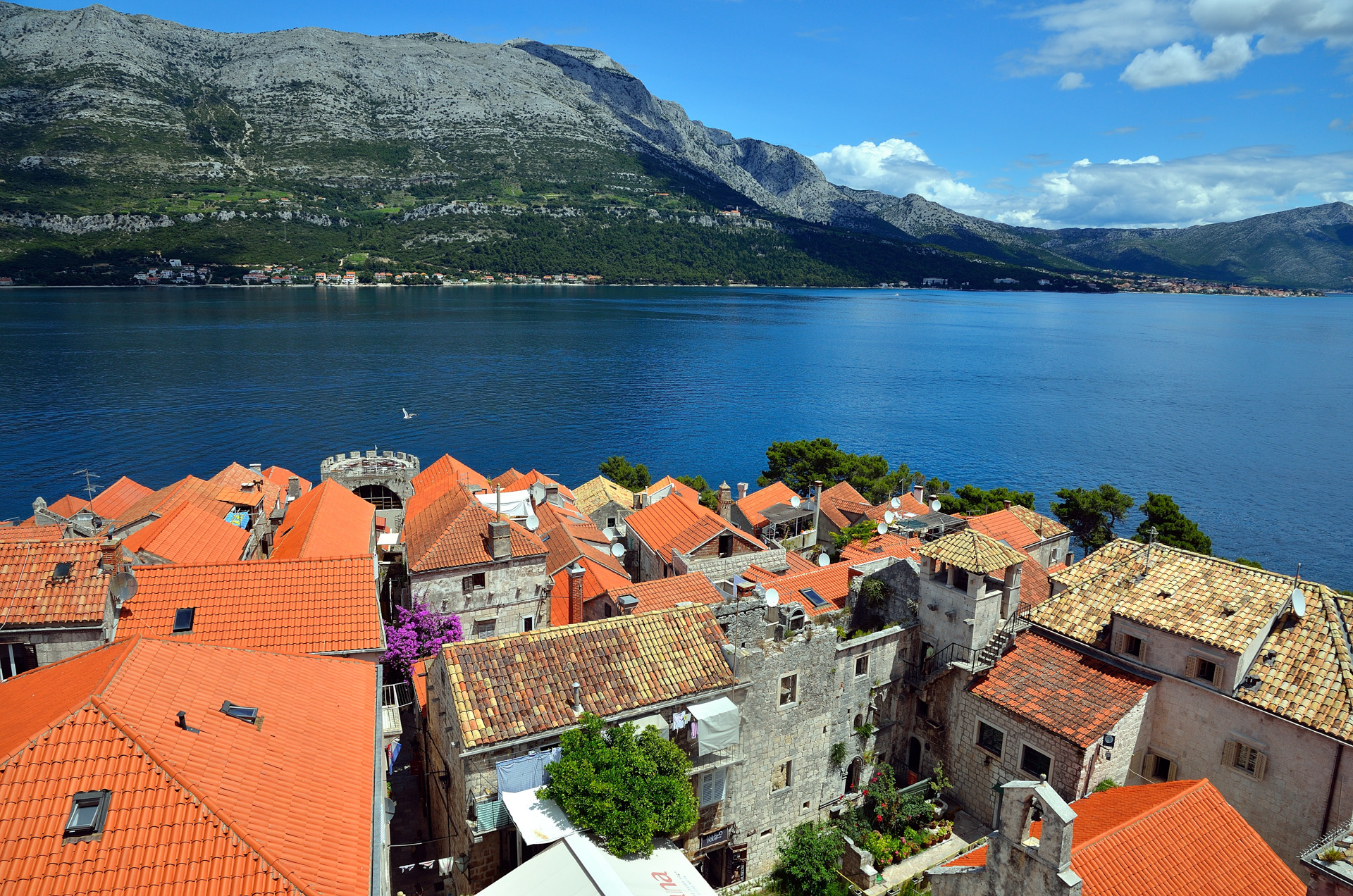 Nach einer Minute war der Spuk vorbei und ich hatte die Hände wieder frei zum Fotografieren. Wir schauen über die Dächer von Korcula nach Orebic und dahinter der Berg Sv.Ilja...