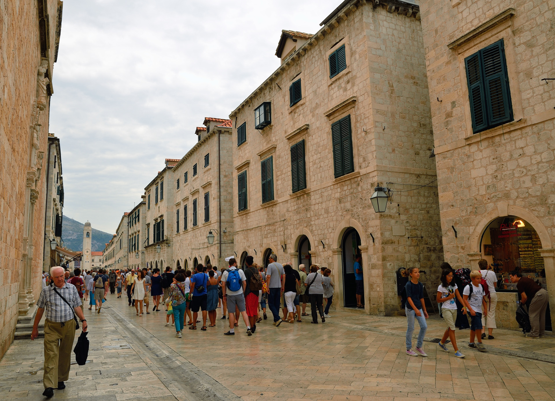 Wir sind unterwegs auf dem Stradun, die Mainstreet in Dubrovnik. Diese Straße ist zugleich die kürzeste Verbindung zwischen dem westlichen und dem östlichen Stadttor. Sie entstand am Ende des 11. Jahrhunderts. Dort finden heute alle großen Festveranstaltungen und Prozessionen statt, aber diese Straße ist zugleich die Handelsarterie des alten Stadtkerns von Dubrovnik...