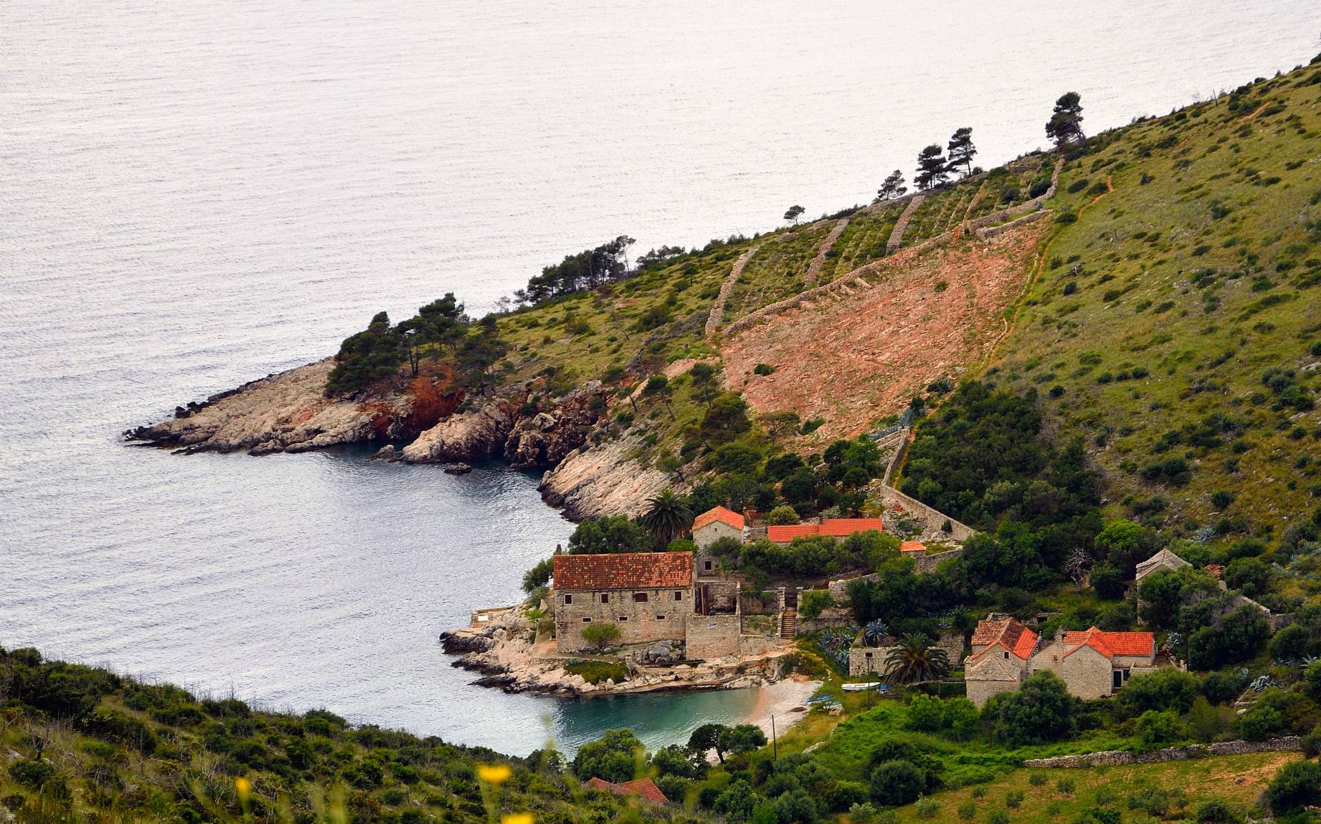 ...Hinter dem Tunnel Stari Grad - Hvar in der Bucht von Dubovica verlassen wir die asphaltierte Strasse und biegen ab nach Südosten oberhalb der Steilküste, Blick auf Dubovica, im Sommer eine beliebte Badebucht mit Konoba, allerding nur zu Fuss oder mit 4x4 erreichbar...