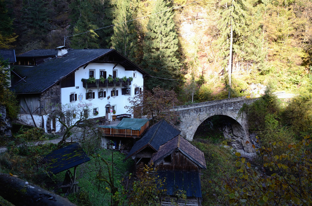 Die Obertalmühle - von den meisten kurz Talmühle genannt - liegt eingebettet von zwei noch gut erhaltenen Stein-Brücken aus der Römerzeit zwischen Völlan und Tisens auf etwa 700m über dem Meeresspiegel. Seit über 200 Jahren befindet sich die Talmühle im Familienbesitz der Familie Prinoth, wird von dieser seit Generationen bewirtschaftet und ist eine der ältesten heutzutage noch funktionierenden Mühlen.