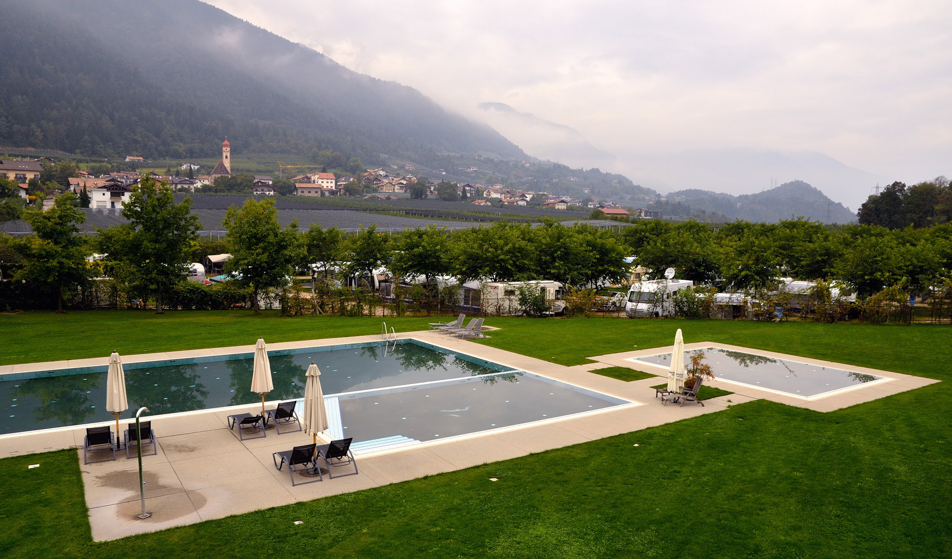 Der Naturcaravanpark und Comfort Camping Tisens liegt sehr sch�uf einen Hochplateau zwischen Bozen und Meran. Ein 25 m langes beheiztes Schwimmbad sowie unser beheiztes Nicht-Schwimmerbecken mit einer 4000 qm gro�n Liegewiese sind eine kleine Oase mitten in den S�ler Alpen. Und so kommt es auch, dass wir die erste Nacht vorm CP auf dem Wohnmobilstellplatz verbringen m�weil der Platz Ende September noch voll ist.