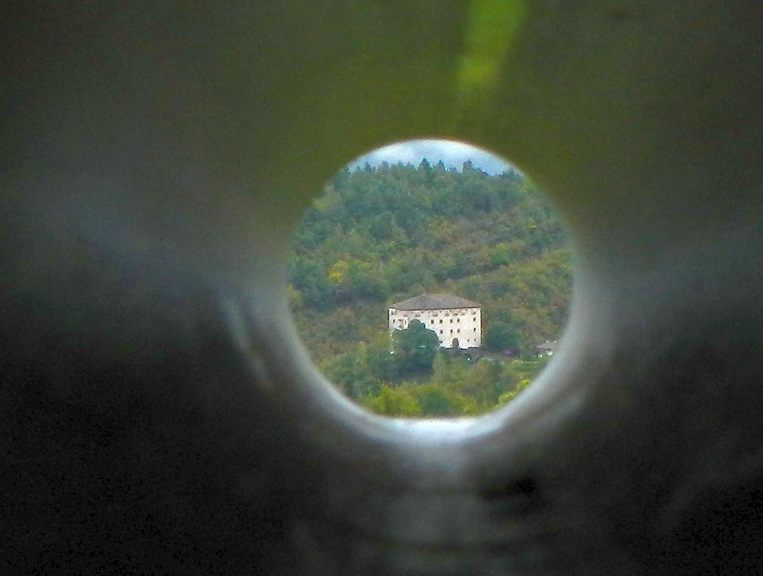 Schloss Katzenzungen, noch in der Ferne - durch ein Fernrohr, montiert auf einen Stativ, aufgenommen.