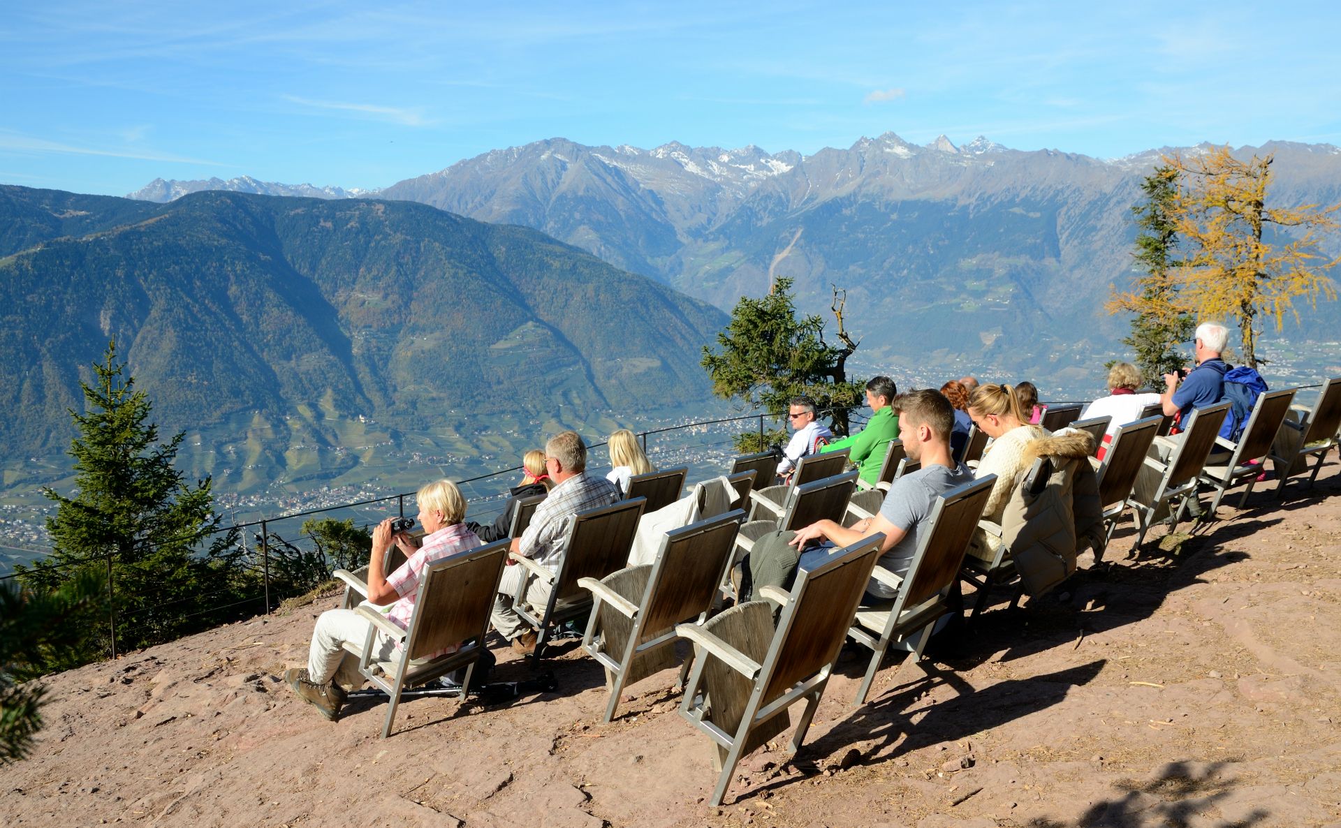 Wir erreichen das Knottnkino, das im Jahr 2000 vom Bozner Künstler Franz Messner geschaffen wurde. Es besteht aus 30 wetterfesten Klappsesseln aus Stahl und Kastanienholz. Sie dienen dem Wanderer als Aufforderung, Platz zu nehmen und die Aussicht in wechselndem Licht mit treibenden Wolken wie in einem Kino zu genießen, bei dem die Natur die Regie führt. Es besteht auf diese Weise je nach Wetter, Wind, Sicht und Helligkeit aus dem Kinosessel heraus ein sich stets ändernder Ausblick auf das Etschtal mit dem Meraner Becken einschließlich Seitentälern und angrenzenden Bergen...